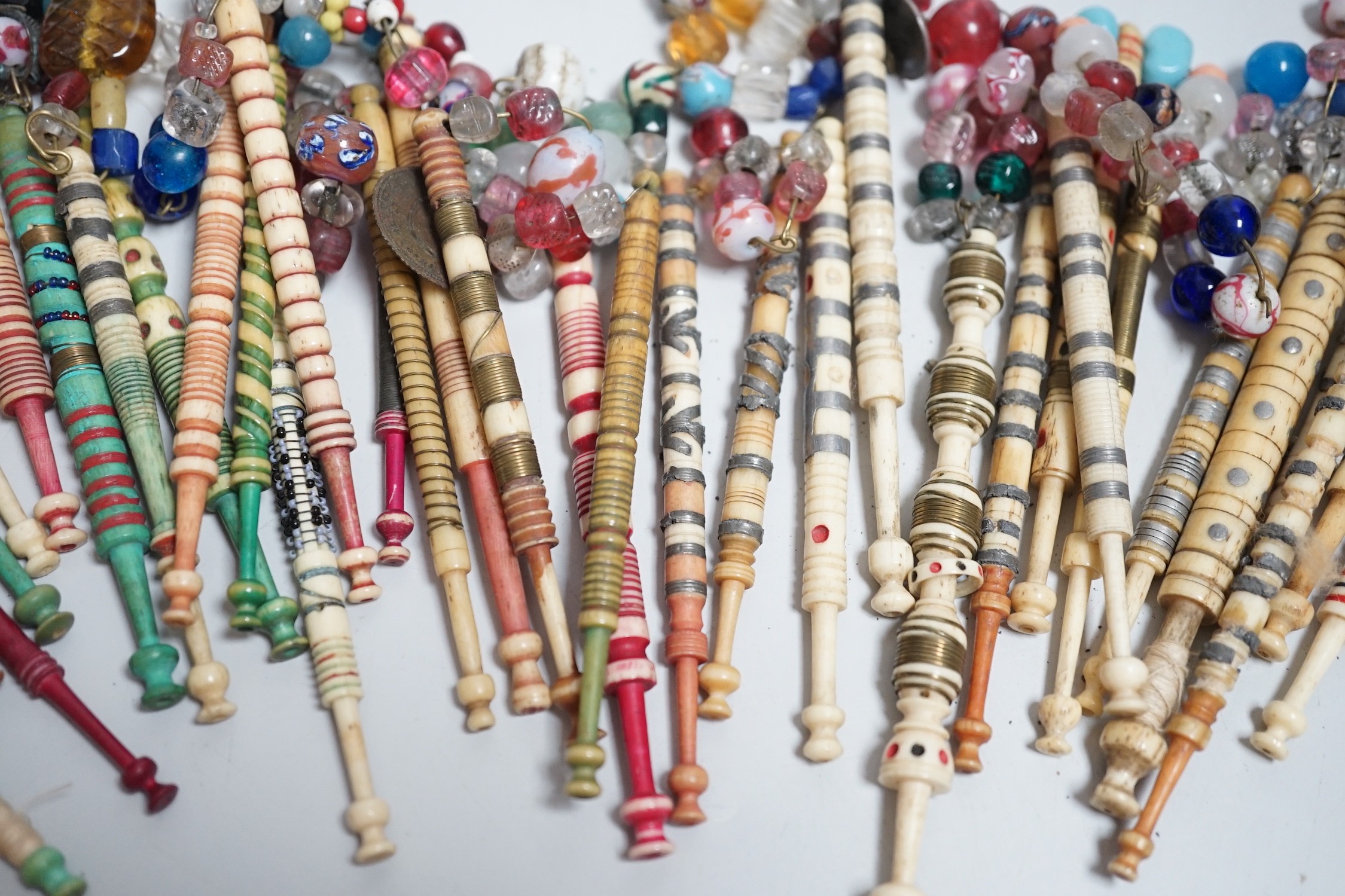 Twenty one 19th century stained and turned bone lace bobbins with glass bead tops and thirteen ornate bone and metal decorated lace bobbins with bead tops (35)